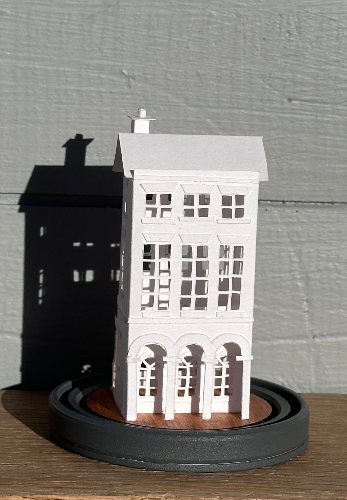 three storey paper house with triple arched colonnade on grey painted base 