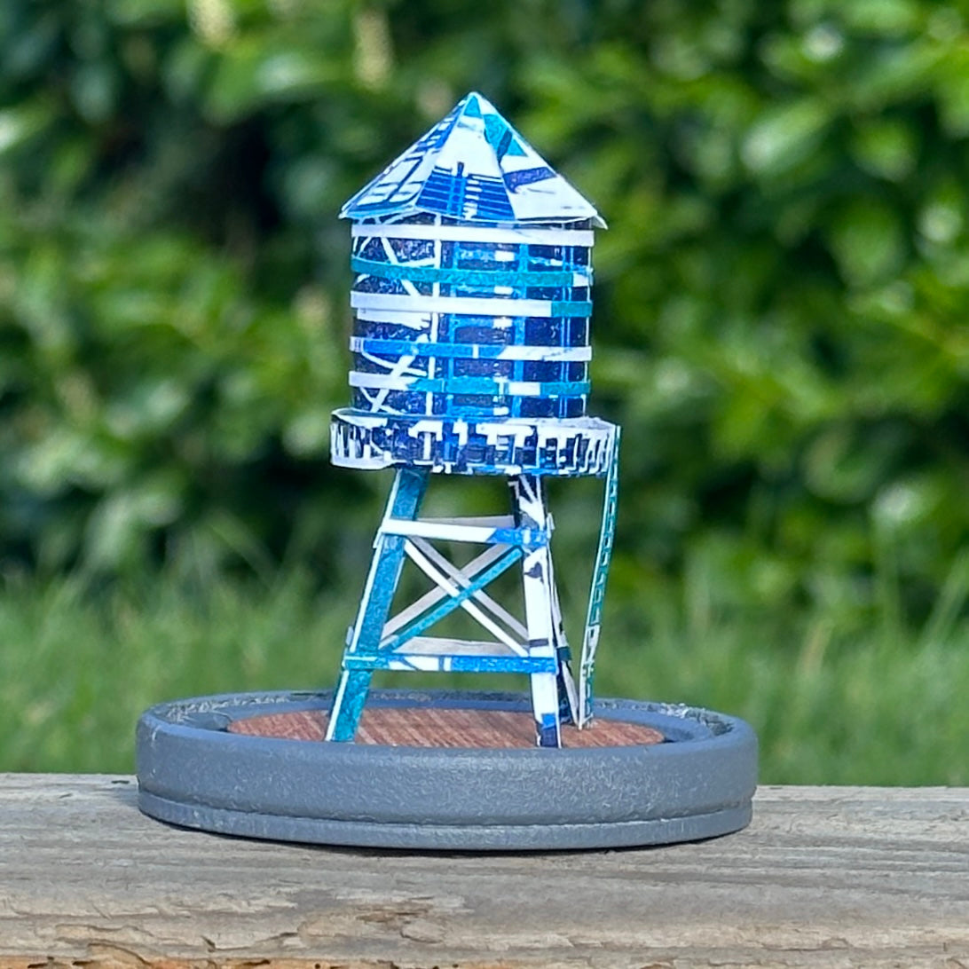 Handcut paper water tower over printed in shades of blue on grey base