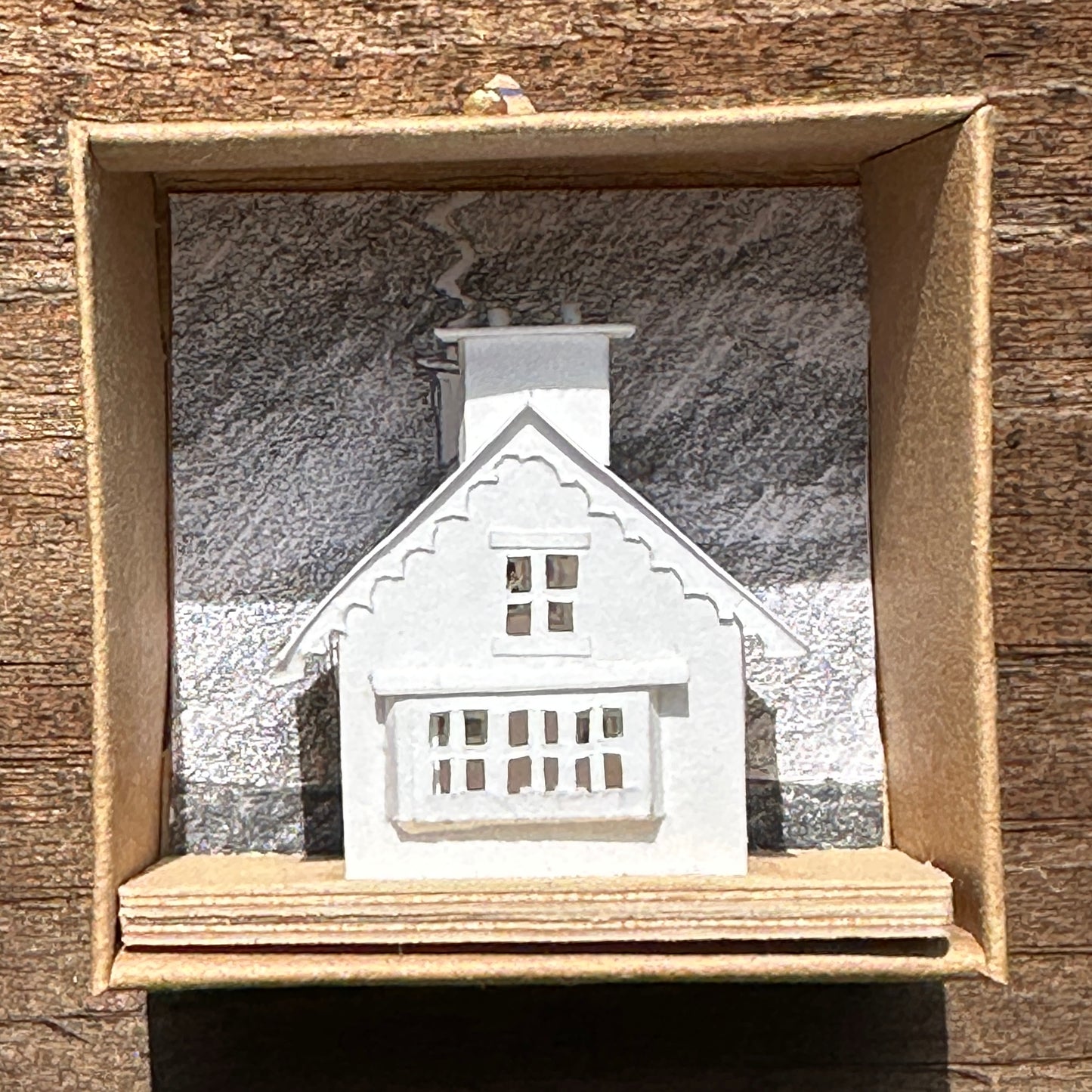 white paper gable fronted house with double chimney on plywood base in presentation box