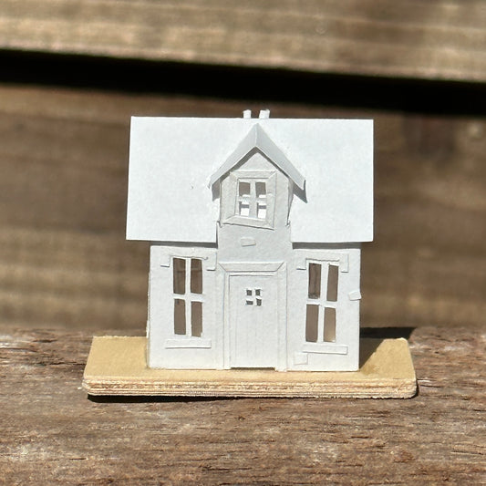 Miniature handmade paper house on plywood base