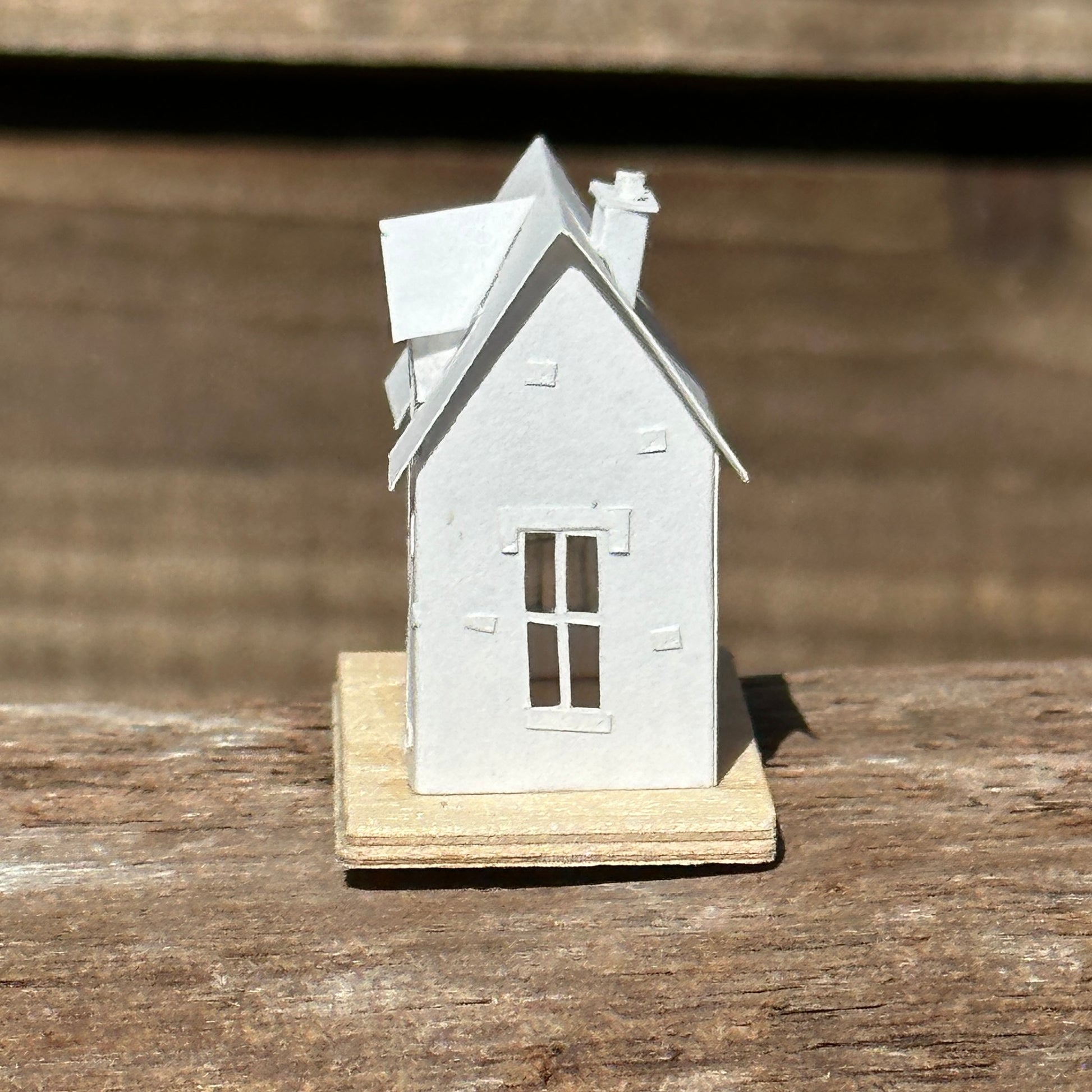  Miniature handmade paper house on plywood base