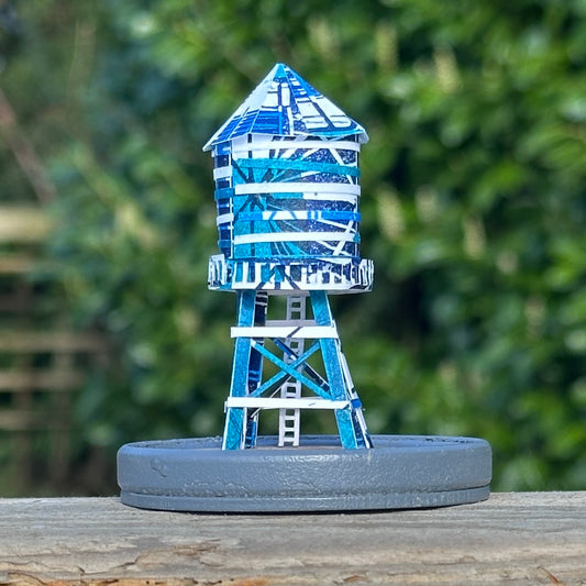 Handcut paper water tower over printed in shades of blue on grey base