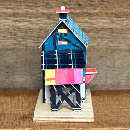 olourful blue and pink house with curved roof extension