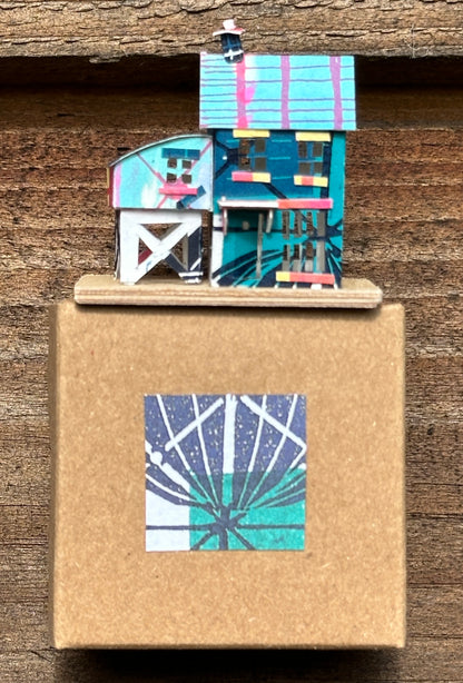 olourful blue and pink house with curved roof extension on presentation box