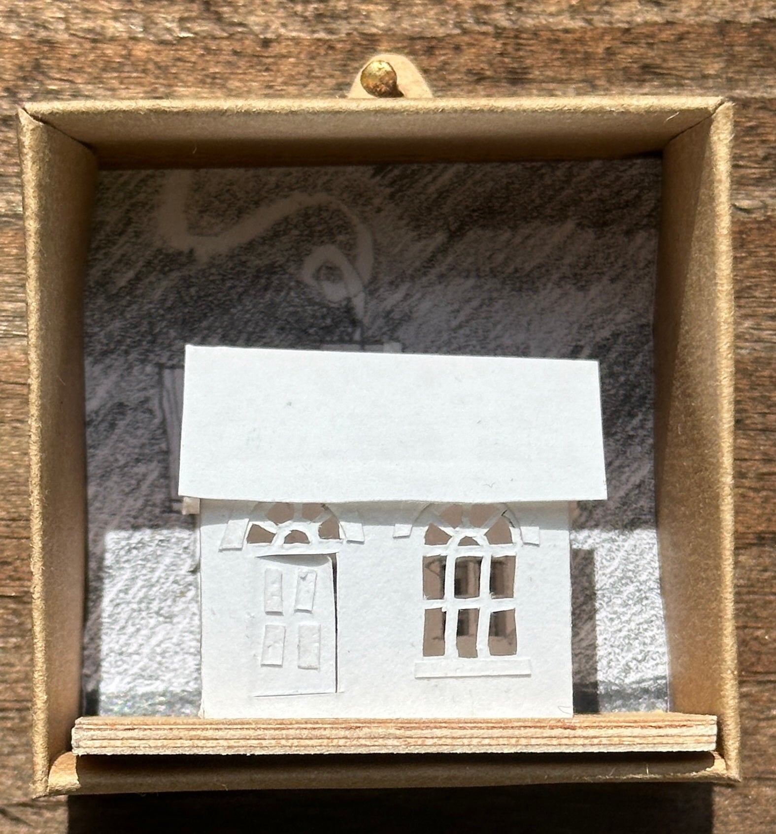 white paper house with arched windows on plywood base