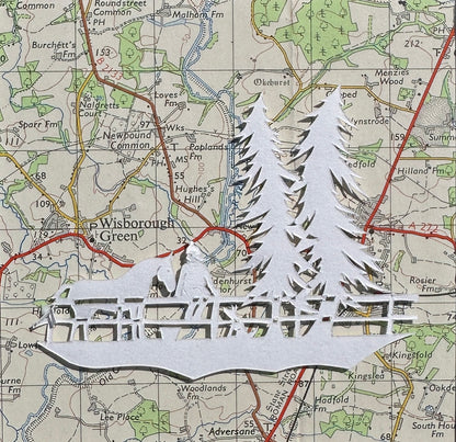 Papercut of a horse, a girl and dog next to two tall fir trees 