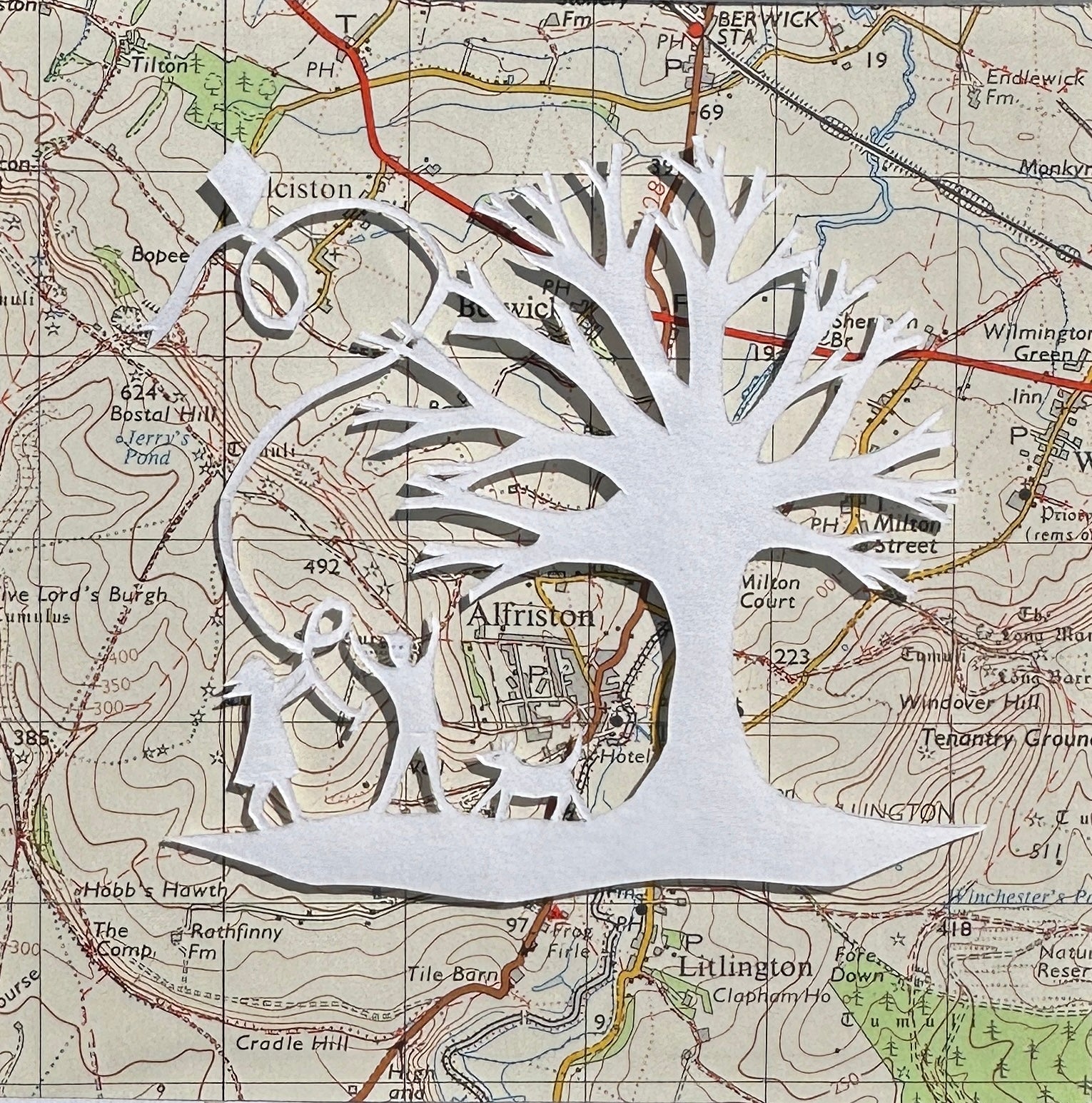 Papercut showing kite flying next to a tree overlaid onto an OS map extract